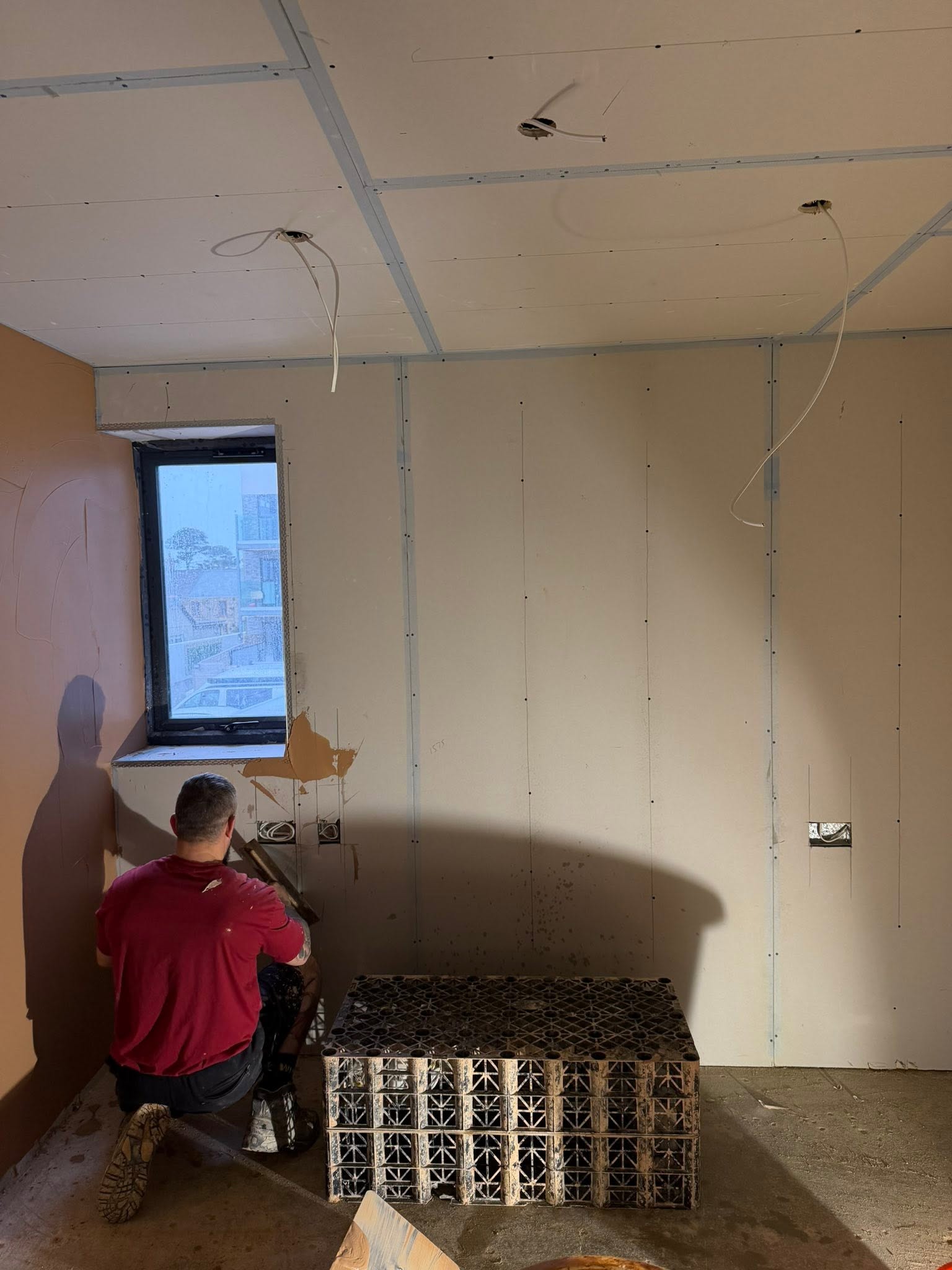 Plasterer working on the lower part of an internal wall