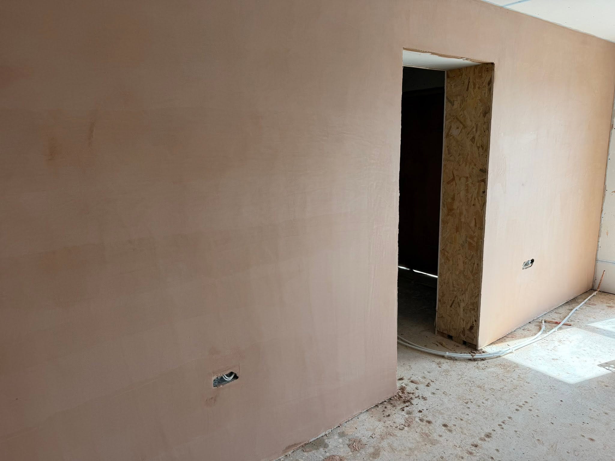 Wide view of freshly plastered walls around an internal doorway