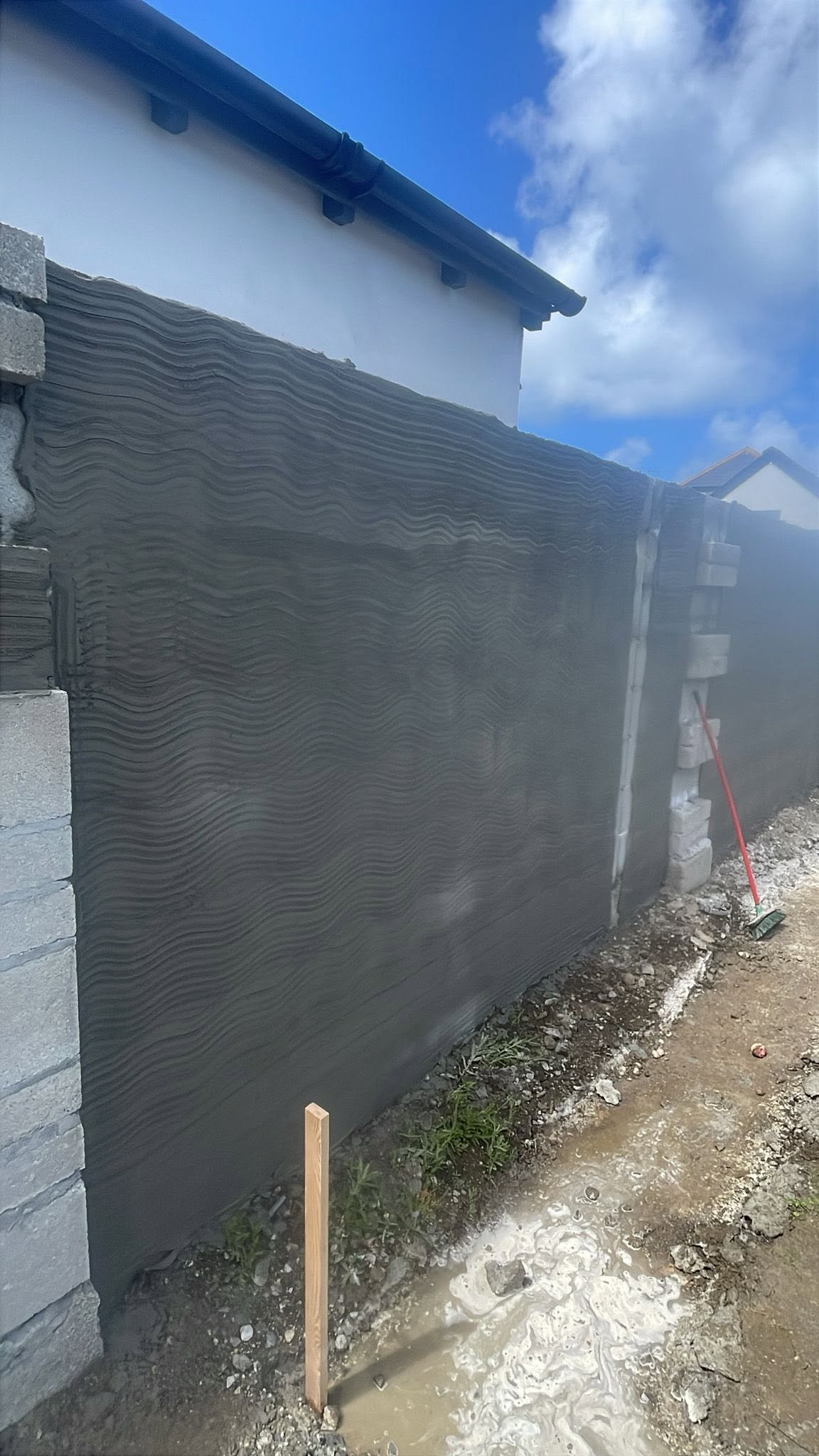 Boundary wall with a horizontally scored scratch coat between exposed block piers