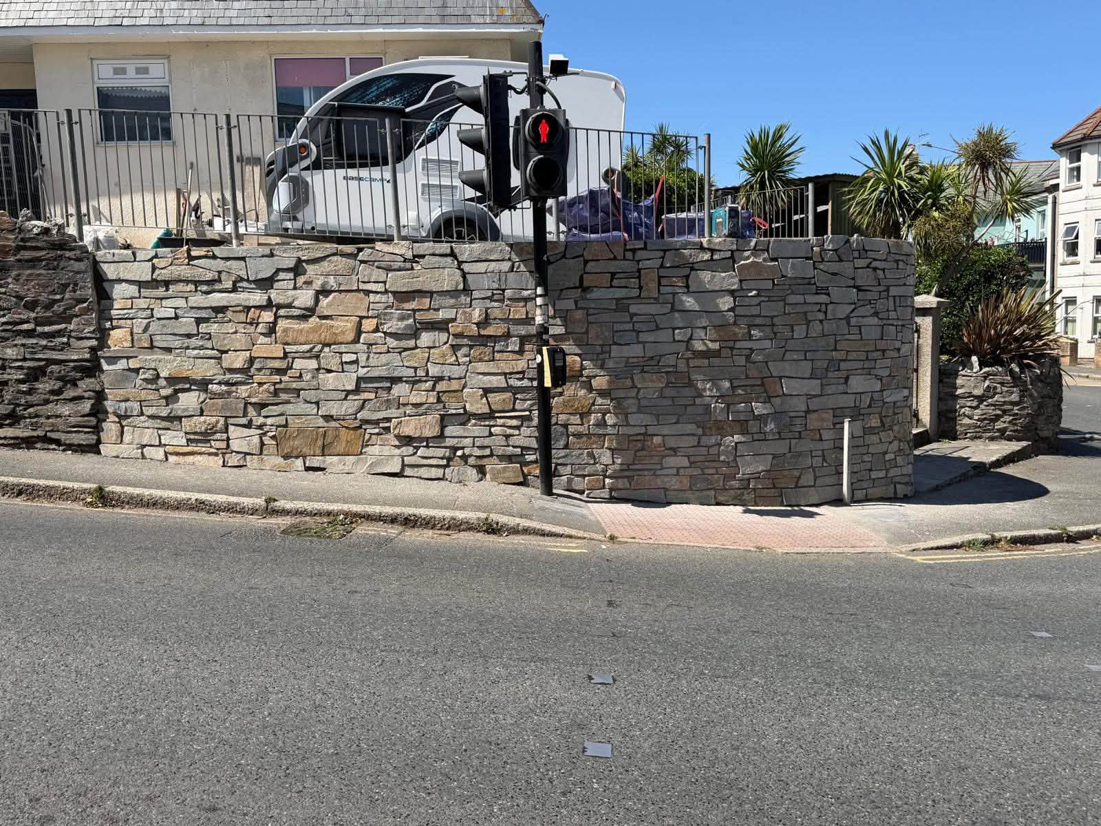 Completed natural stone boundary wall with curved corner in Newquay